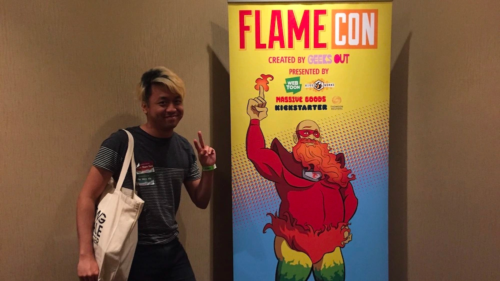 Destructoid's Chris Compendio posing next to a Flamie pull-up sign.